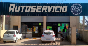Fachada del Autoservicio Teo con autos estacionados en la entrada